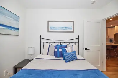 a bedroom with a bed with blue and white pillows at RIVERSIDE WALK in Niagara Falls