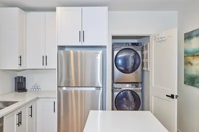 a white kitchen with two washer and dryer at RIVERSIDE WALK in Niagara Falls