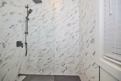 a bathroom with a shower with white subway tiles at RIVERSIDE WALK in Niagara Falls