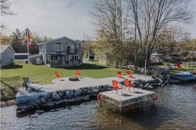 a dock with chairs and a house in the water at Riverview Cottage Escape in Frankford