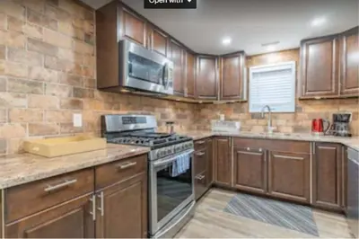 a kitchen with wooden cabinets and a stove top oven at Riverview Cottage Escape in Frankford