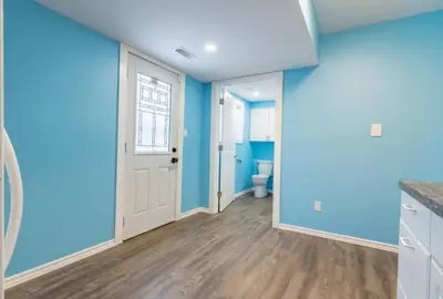 an empty kitchen with blue walls and wooden floors at Riverview Cottage Escape in Frankford