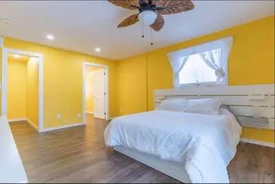 a bedroom with a white bed and a ceiling fan at Riverview Cottage Escape in Frankford