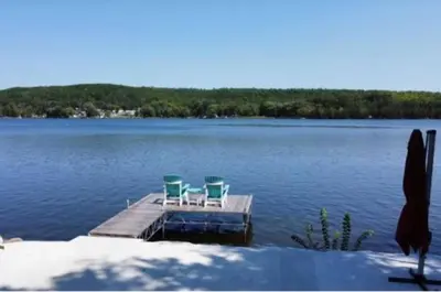 two chairs on a dock in the middle of a lake at Riverview Cottage Escape in Frankford