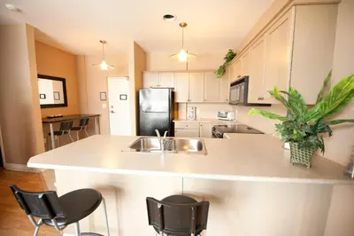 a kitchen with a sink and a counter with chairs at SUPERIOR 3 in Niagara Falls