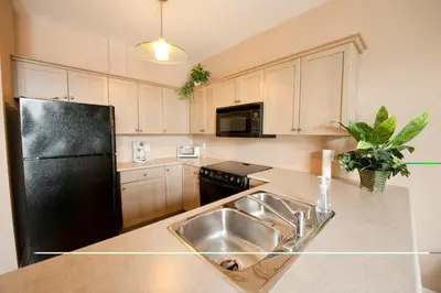 a kitchen with a sink and a black refrigerator at SUPERIOR 3 in Niagara Falls