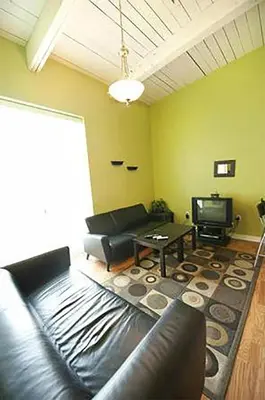 a living room with a leather couch and a tv at Superior 4 in Niagara Falls