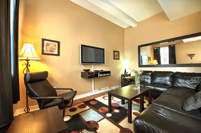 a living room with a leather couch and a tv at Superior 5 in Niagara Falls
