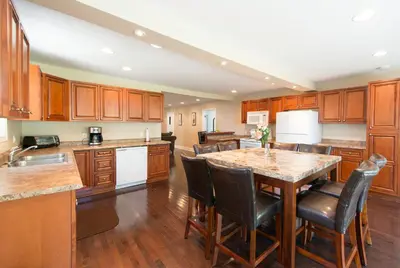 a kitchen with wooden cabinets and a table with chairs at WALK TO THE BEACH in Fort Erie