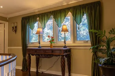 a table with two lamps in a room with windows at Elegant Mansion with Private Bar & Game Lounge in Mississauga