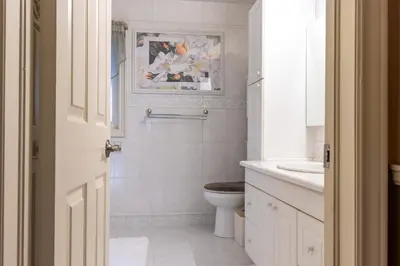 a white bathroom with a toilet and a sink at Elegant Mansion with Private Bar & Game Lounge in Mississauga