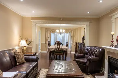 a living room with leather furniture and a dining room at Elegant Mansion with Private Bar & Game Lounge in Mississauga