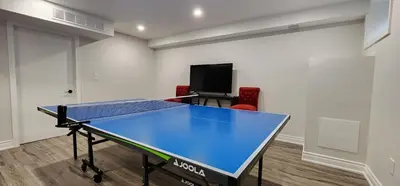 a ping pong table in a room with a tv at 6BR Luxe Family Home,Safari Area, Entertainment in Milton