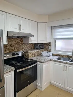 a kitchen with white cabinets and a stove top oven at Newly Renovated 3BR Upper Unit - Bright & Quiet in Richmond Hill
