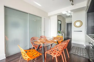 a dining room with orange chairs and a table at Bright High Floor1 Bedroom Condo Downtown Toronto in Toronto