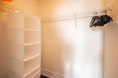 a closet with white shelves and a curtain at Bright High Floor1 Bedroom Condo Downtown Toronto in Toronto