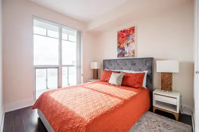 a bedroom with a bed and a large window at Bright High Floor1 Bedroom Condo Downtown Toronto in Toronto