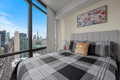 a bedroom with a bed and a large window at High Floor 1 Bedroom Condo City View Downtown Toronto in Toronto