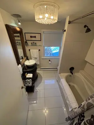 a bathroom with a tub and a sink and a mirror at Vintage Pines Guest House in Niagara on the Lake