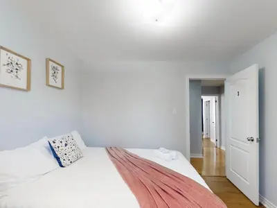 a bedroom with a white bed with a blanket on it at Cozy Queen room with Shared Bath near Seneca Finch 404 in Toronto