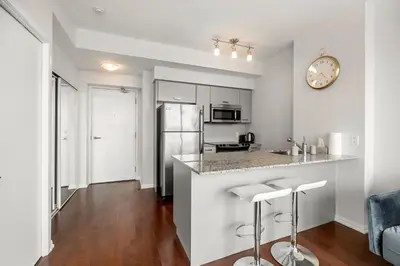 a kitchen with a counter and stools in a room at 1 Bedroom Condo Burano Downtown Toronto in Toronto