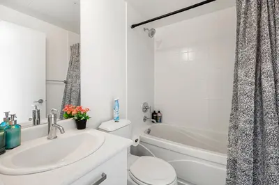 a white bathroom with a sink and a toilet at 1 Bedroom Condo Burano Downtown Toronto in Toronto