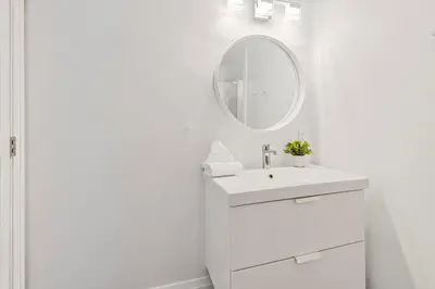 a white bathroom with a sink and a mirror at Hillside Hideaway Ski-In Ski-Out Walk to Village in Blue Mountains