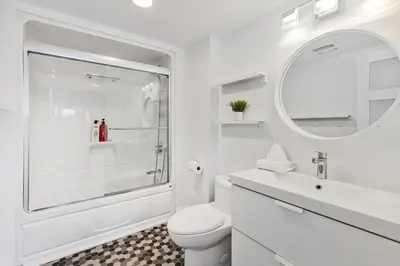 a white bathroom with a shower and a toilet at Hillside Hideaway Ski-In Ski-Out Walk to Village in Blue Mountains