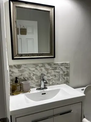 a bathroom with a white sink and a mirror at Cozy 2-Bed with Kitchen and Patio in Midtown Toronto in Toronto