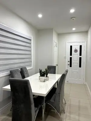 a dining room with a white table and chairs at Cozy 2-Bed with Kitchen and Patio in Midtown Toronto in Toronto