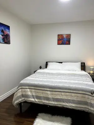 a bedroom with a bed with two pictures on the wall at Cozy 2-Bed with Kitchen and Patio in Midtown Toronto in Toronto