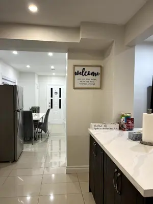 a kitchen with a refrigerator and a dining room at Cozy 2-Bed with Kitchen and Patio in Midtown Toronto in Toronto