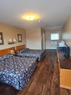 a hotel room with two beds and a television at Skyways Motel in Gravenhurst