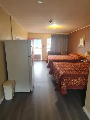 a hotel room with two beds and a refrigerator at Skyways Motel in Gravenhurst