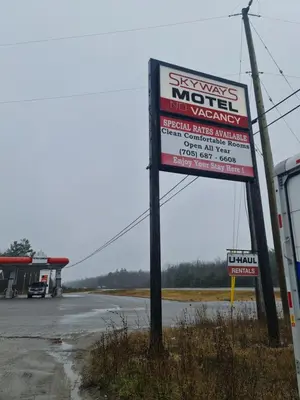 a sign for a motel in a parking lot at Skyways Motel in Gravenhurst