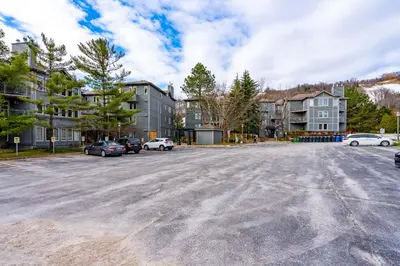 a parking lot with cars parked in front of buildings at Easy Rider Chalet Steps to Lift & Blue Village in Blue Mountains