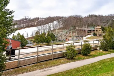 a fence next to a road with a playground at Easy Rider Chalet Steps to Lift & Blue Village in Blue Mountains