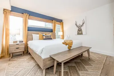 a bedroom with a large bed and a wooden table at Lift Side Luxury Newly renovated walk to village in Blue Mountains