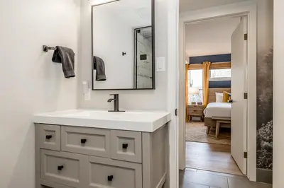 a bathroom with a white sink and a mirror at Lift Side Luxury Newly renovated walk to village in Blue Mountains