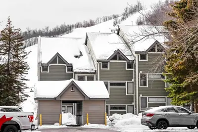 a house with a car parked in front of it at First Tracks Ski-In Ski-Out & Walk to Village in Blue Mountains