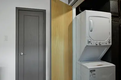 a kitchen with a washer and dryer next to a door at First Tracks Ski-In Ski-Out & Walk to Village in Blue Mountains