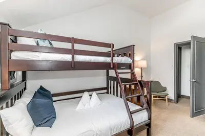 a bedroom with two bunk beds and a ladder at First Tracks Ski-In Ski-Out & Walk to Village in Blue Mountains