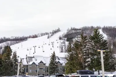 a snow covered ski slope with a ski lift at First Tracks Ski-In Ski-Out & Walk to Village in Blue Mountains
