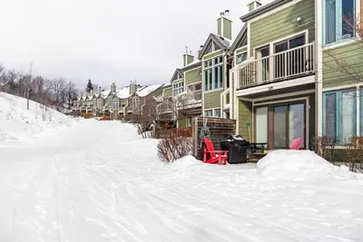 a snow covered street with a row of houses at First Tracks Ski-In Ski-Out & Walk to Village in Blue Mountains
