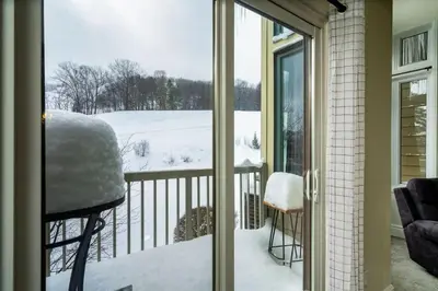 a balcony with a view of a snow covered yard at Slopeside Haven - Ski-In Ski-Out Adventure Base in Blue Mountains