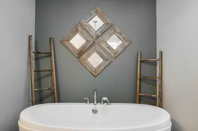 a bathroom with a white tub and a mirror on the wall at Slopeside Haven - Ski-In Ski-Out Adventure Base in Blue Mountains