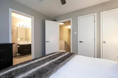 a bedroom with a white bed and a bathroom at Hillside Lookout - Ski-In Ski-Out Alpine Escape in Blue Mountains