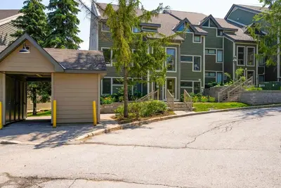 a house with a garage in front of a street at Hillside Lookout - Ski-In Ski-Out Alpine Escape in Blue Mountains