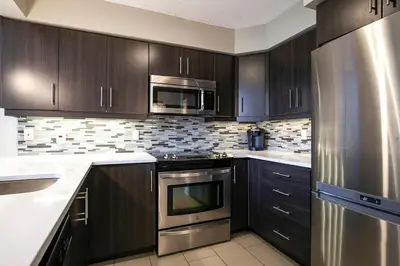 a kitchen with dark wood cabinets and stainless steel appliances at Hillside Lookout - Ski-In Ski-Out Alpine Escape in Blue Mountains