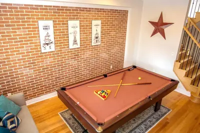 a ping pong table in a room with a brick wall at Large 4 Br - 5 Bathroom with Heated Pool 2 King beds Sauna Pool Table in Blue Mountains